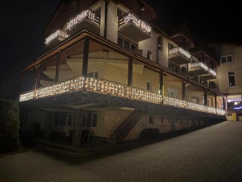 a building with lights on the side of it at night at Pensiunea Carmen - Bikers Friendly Nest in Sibiu