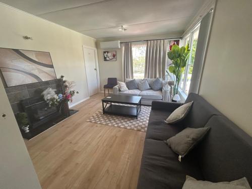 a living room with a couch and a fireplace at Auckland Northcote Holiday home in Auckland
