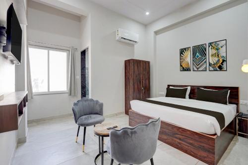 a bedroom with a bed and a table and chairs at Collection O Kesar Crossway Jaipur Formerly Laxmi Palace in Jaipur