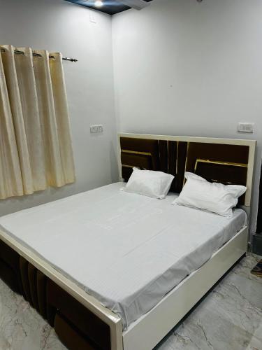 a large bed with white sheets and pillows on it at Shri omkarnath Guest house Ayodhya in Ayodhya