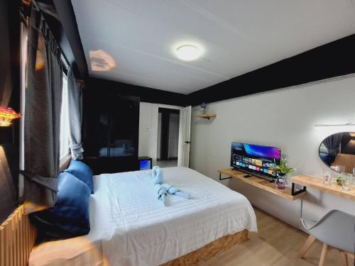 a bedroom with a large bed and a television at Irich Theparak S207- Bts-Chang Erawan 2kms in Ban Khlong Hua Sakae