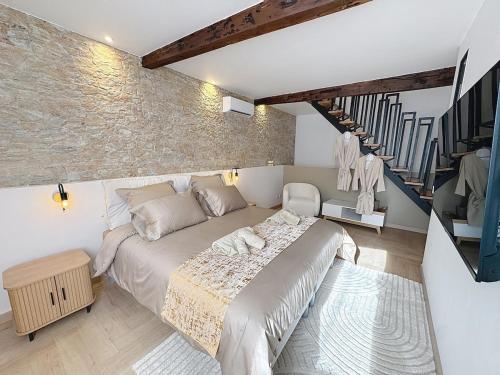 圣贝尔特朗德科曼日L'élégance au Comminges - balnéo, cinéma & confort的一间带大床和石墙的卧室