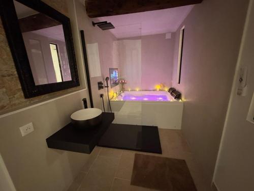圣贝尔特朗德科曼日L'élégance au Comminges - balnéo, cinéma & confort的浴室配有紫色浴缸和水槽
