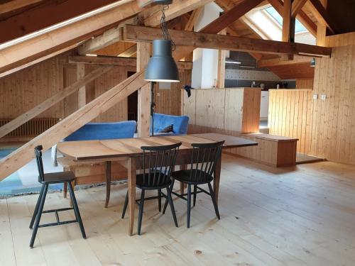 uma sala de jantar com mesa e cadeiras de madeira em Barba Peder Biobergün em Bergün