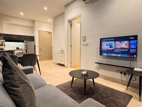 a living room with a couch and a flat screen tv at Lucentia Residence by Infinity swimming pool,lalaport KL in Kuala Lumpur