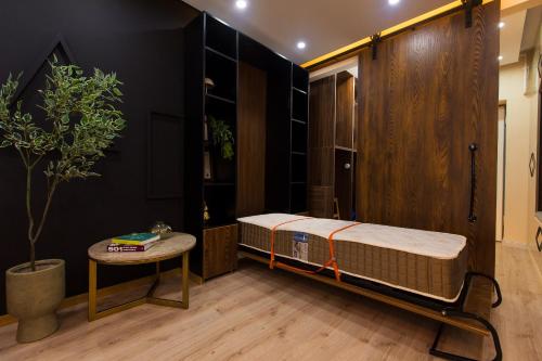 une chambre avec un lit, une table et une plante dans l'établissement Quiet Premium Studio at Ivory Residence Pipera, à Bucarest