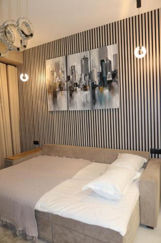 a bedroom with a bed with a picture on the wall at Аренда квартиры #19 NRG U-Tower Rent an apartment in Tashkent