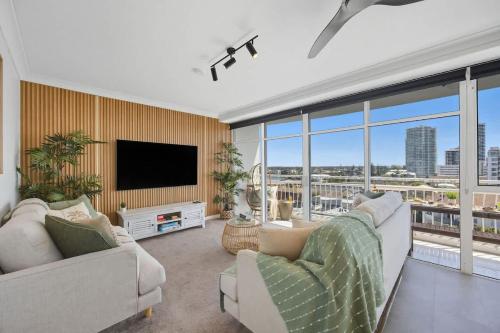 a living room with two couches and a flat screen tv at 2BR Beachfront Pool Spa Sauna in Gold Coast