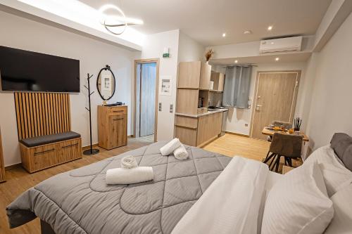 une chambre avec un grand lit avec des serviettes dessus dans l'établissement Gina's Apartments, à Spáta