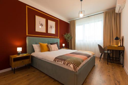ein Schlafzimmer mit einem Bett mit orangefarbenen Wänden und einem Fenster in der Unterkunft Contemporary 1-Bedroom Oasis in Pipera - Ivory Residence in Bukarest