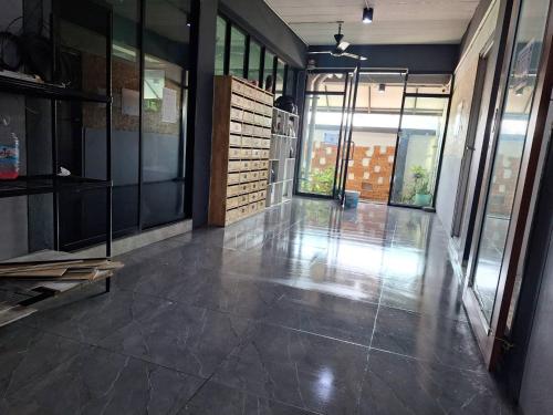 an empty room with glass doors and a tile floor at Irich Theparak S207- Bts-Chang Erawan 2kms in Ban Khlong Hua Sakae