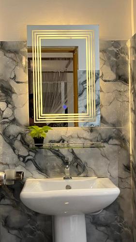 a bathroom with a sink and a mirror at Mirewon Guest in Weligama