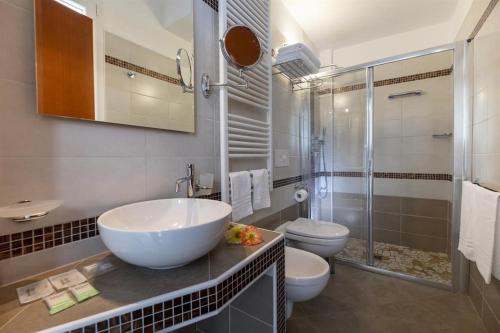 Un baño con lavabo, inodoro y ducha. en Hotel Elios, en Bellaria-Igea Marina