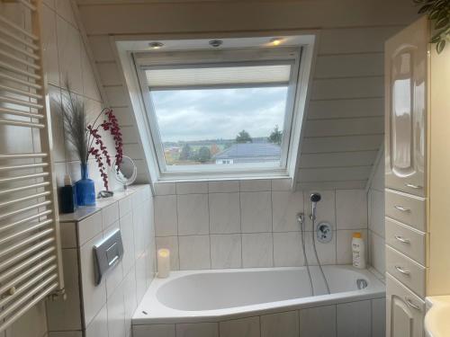a bath tub in a bathroom with a window at Konfortable Wohnung mit Balkon und Gartenblick in Hungen