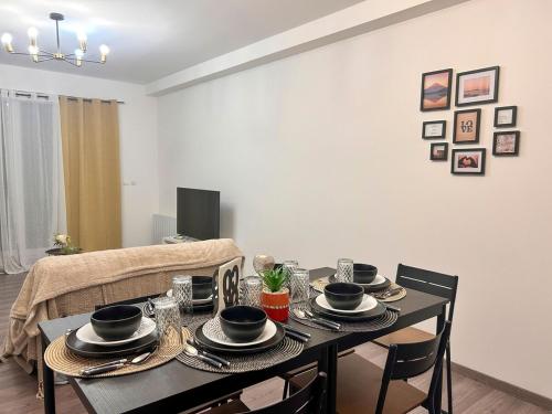 ein Esszimmer mit einem Tisch mit Tellern und Geschirr in der Unterkunft Appartement avec 2 chambres Jardin privé parking gratuit in Clermont-Ferrand