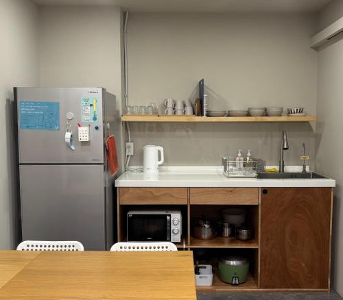 a kitchen with a refrigerator and a counter top at DONGMEN 3 Hostel in Taipei
