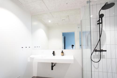 um banheiro branco com pia e chuveiro em Hotel Djurhuus em Tórshavn