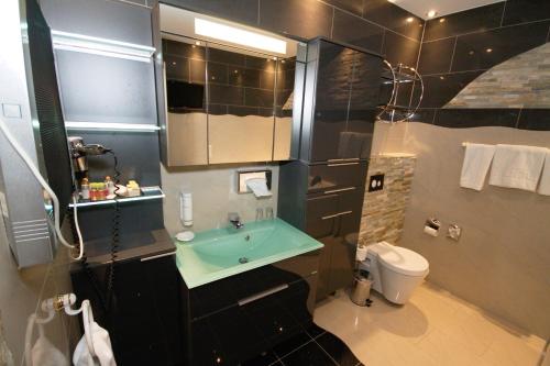 a bathroom with a sink and a toilet at Atlas Grand Hotel in Garmisch-Partenkirchen