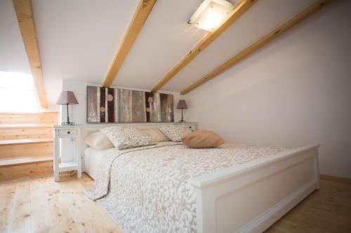 a bedroom with a white bed in a attic at Dalmatinisches Haus In Der Altstadt Von Split in Split