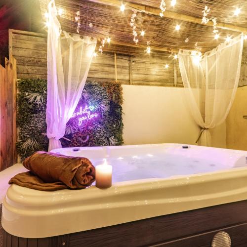 a bath tub with a candle in a room at Le Havre de Pierres, Puy du Foù in Mauléon