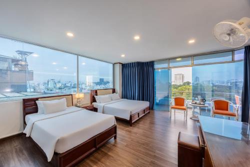 a hotel room with two beds and a desk at A25 Hotel - 251 Hai Bà Trưng HCM in Ho Chi Minh City