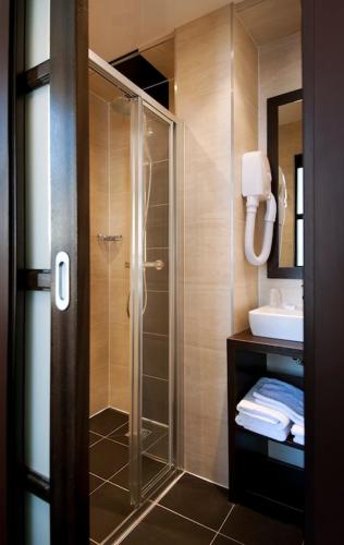 a bathroom with a shower with a glass door at Hotel Choiseul Opera in Paris
