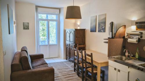 a kitchen with a couch and a table in a room at Appartement 6 pers allée d étigny in Luchon