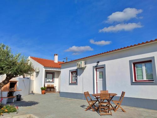a patio with a table and chairs in front of a house at Recanto do Ti Ze II in Aldeia do Mato