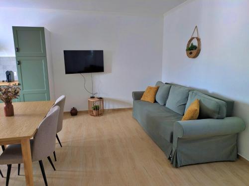 a living room with a blue couch and a table at Recanto do Ti Ze II in Aldeia do Mato