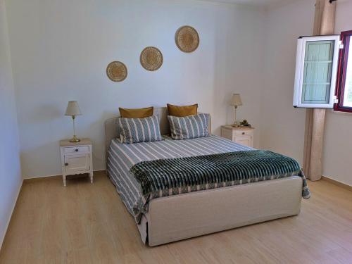 Un dormitorio con una cama y dos mesitas de noche. en Recanto do Ti Ze II, en Aldeia do Mato