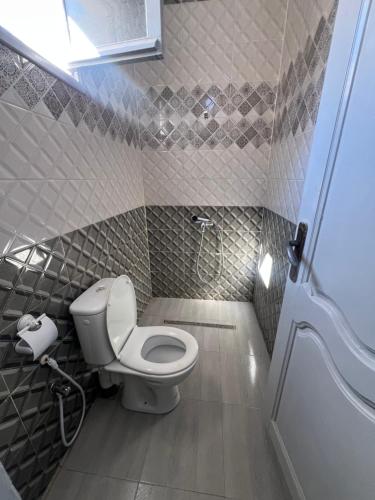 ein kleines Badezimmer mit Toilette und Dusche in der Unterkunft R feto house in Al Ḩārah al Kabīrah