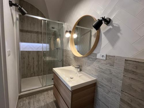 a bathroom with a sink and a shower and a mirror at Apartament Florian Rynek 3 in Radków