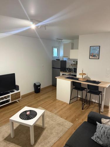 Appartement T2 في داكس: غرفة معيشة بها أريكة وطاولة