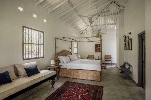a bedroom with a large bed and a couch at Rice House in Habaraduwa