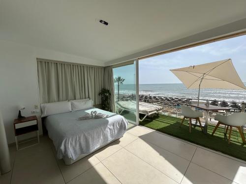 a bedroom with a bed and a view of the ocean at Carihuela Beach Apartamentos in Torremolinos
