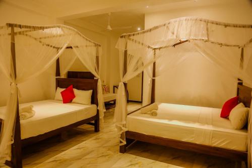 1 Schlafzimmer mit 2 Betten und Moskitonetzen in der Unterkunft Happy Mama Guest Mirissa in Mirissa