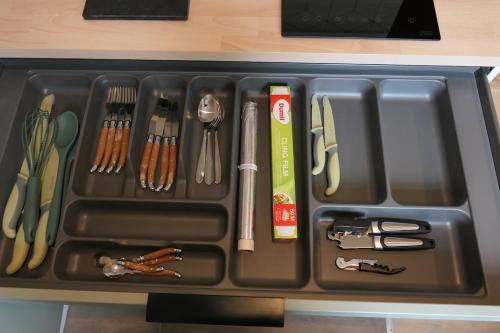 ein schwarzes Tablett mit Küchenutensilien in einer Schublade in der Unterkunft Good Vibes Room in Moissac