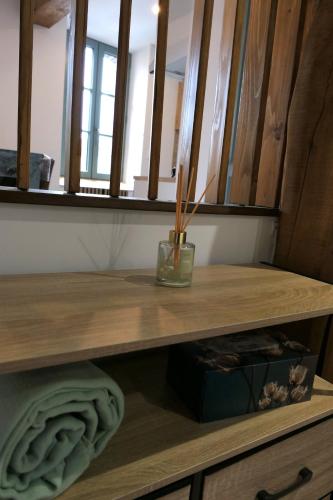 a wooden shelf with a vase on top of it at Good Vibes Room in Moissac