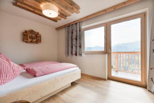 Un dormitorio con una cama y una ventana grande. en SonnenChalet Schlittenstadl, en Ramsau im Zillertal