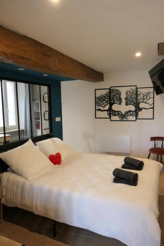 a large white bed with a red flower on it at Good Vibes Room in Moissac