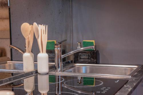 Un fregadero con dos cucharas de madera sobre la encimera. en Lungarno Cellini Firenze, en Florencia