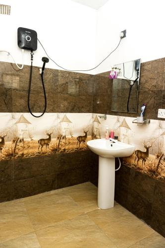 a bathroom with a sink and deer on the wall at behind ocean villa in Weligama