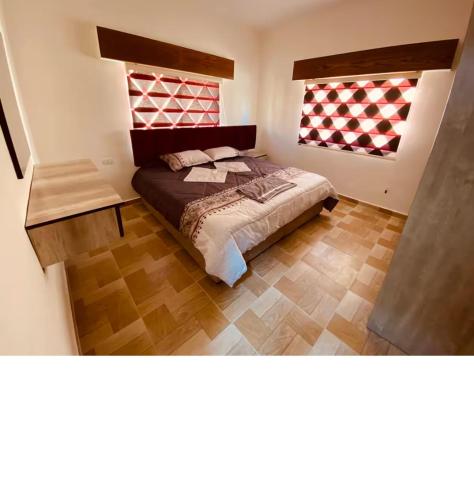 a bedroom with a bed and two windows at New Roman's kingdom in Madaba