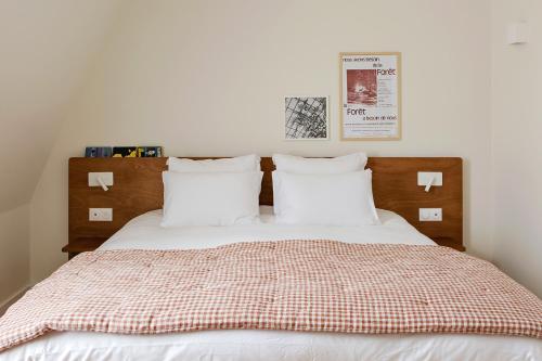 a bedroom with a bed with white sheets and pillows at Alfred Hotels Toulouse Centre Wilson in Toulouse