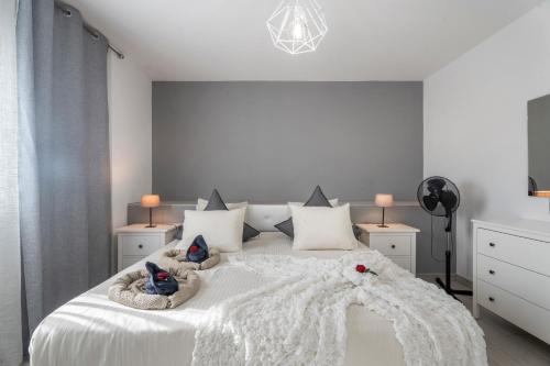 1 dormitorio blanco con 1 cama blanca grande y muebles blancos en 1 Apartamentos Omanai Tenerife Sur, en Las Galletas