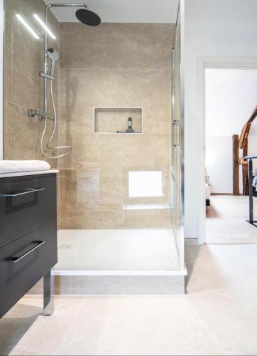 a bathroom with a shower with a glass door at La Grange de Gigi in Givry