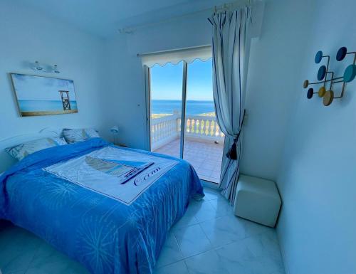 a bedroom with a bed and a balcony with the ocean at Villa de standing 12 couchages - vue sur mer - piscine à débordement chauffée in Albitreccia