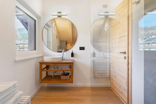 un baño con lavabo y espejo en Appartamento La Téza, en Lavarone