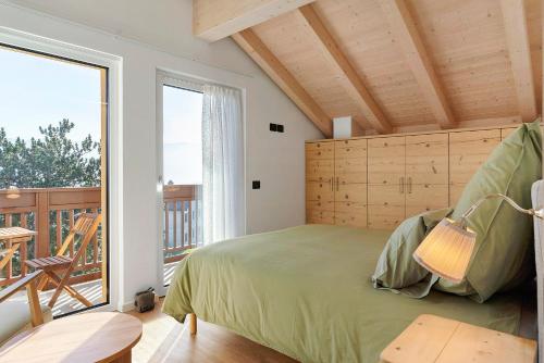 a bedroom with a bed and a balcony at Appartamento La Téza in Lavarone