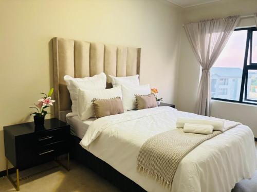 ein Schlafzimmer mit einem großen Bett und einem Fenster in der Unterkunft Cozy getaway in Midrand
